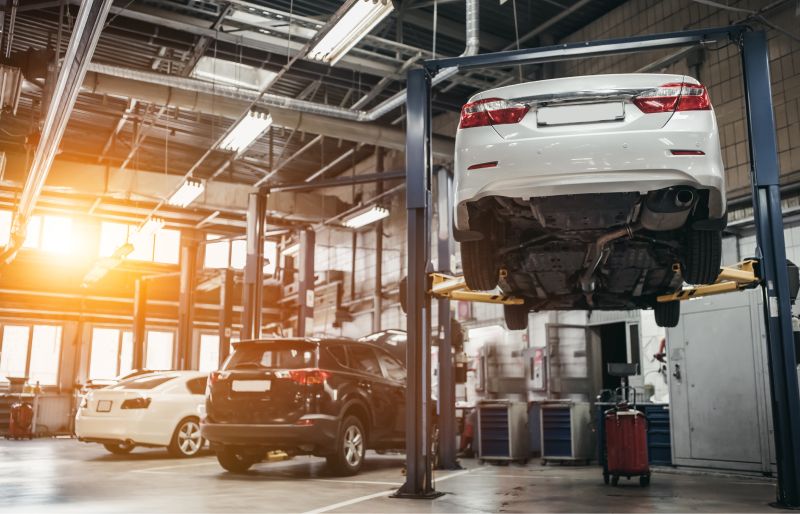 Kfz-Werkstatt von innen mit Auto auf Hebebühne